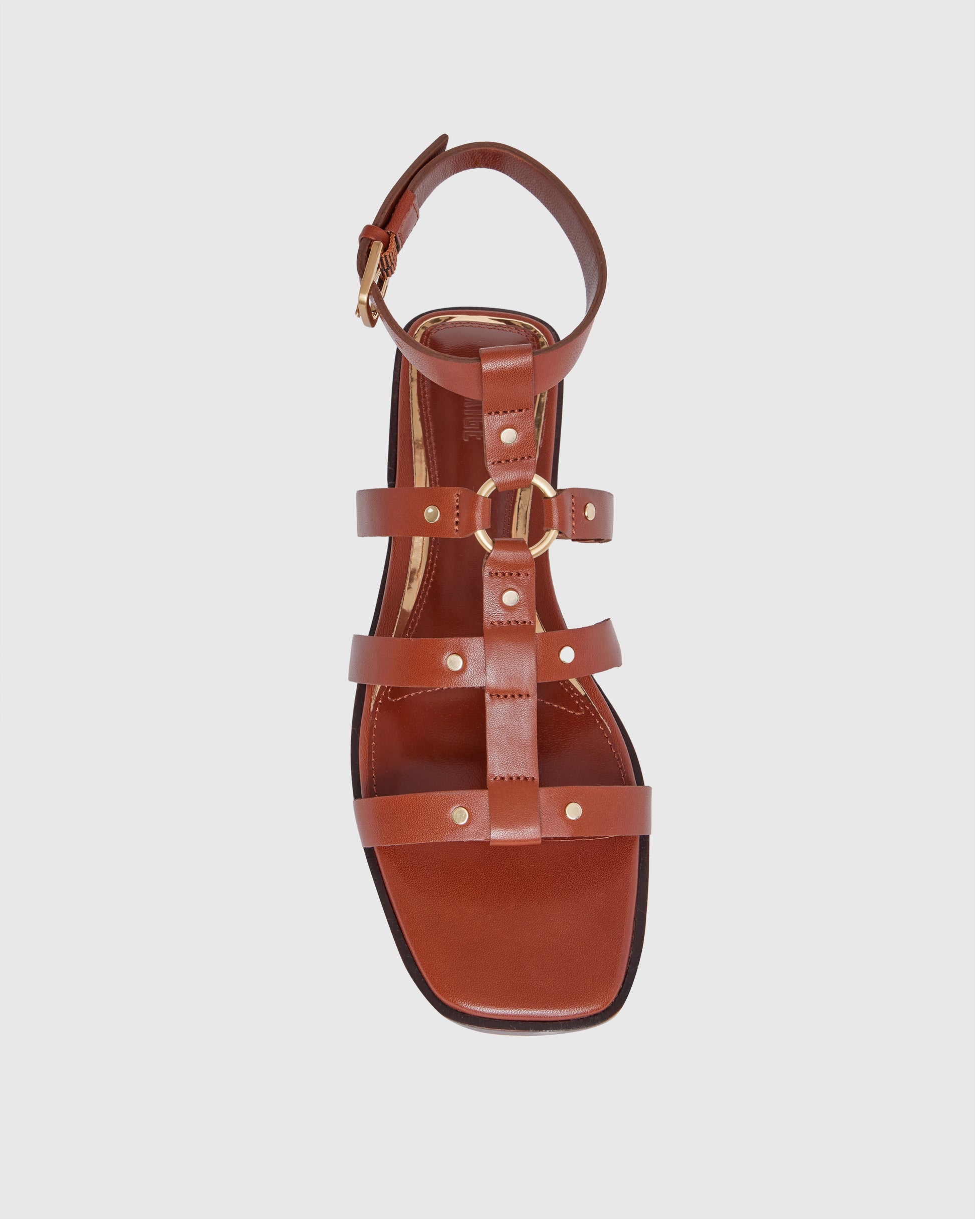 Brown leather sandal with thin straps on a light gray background
