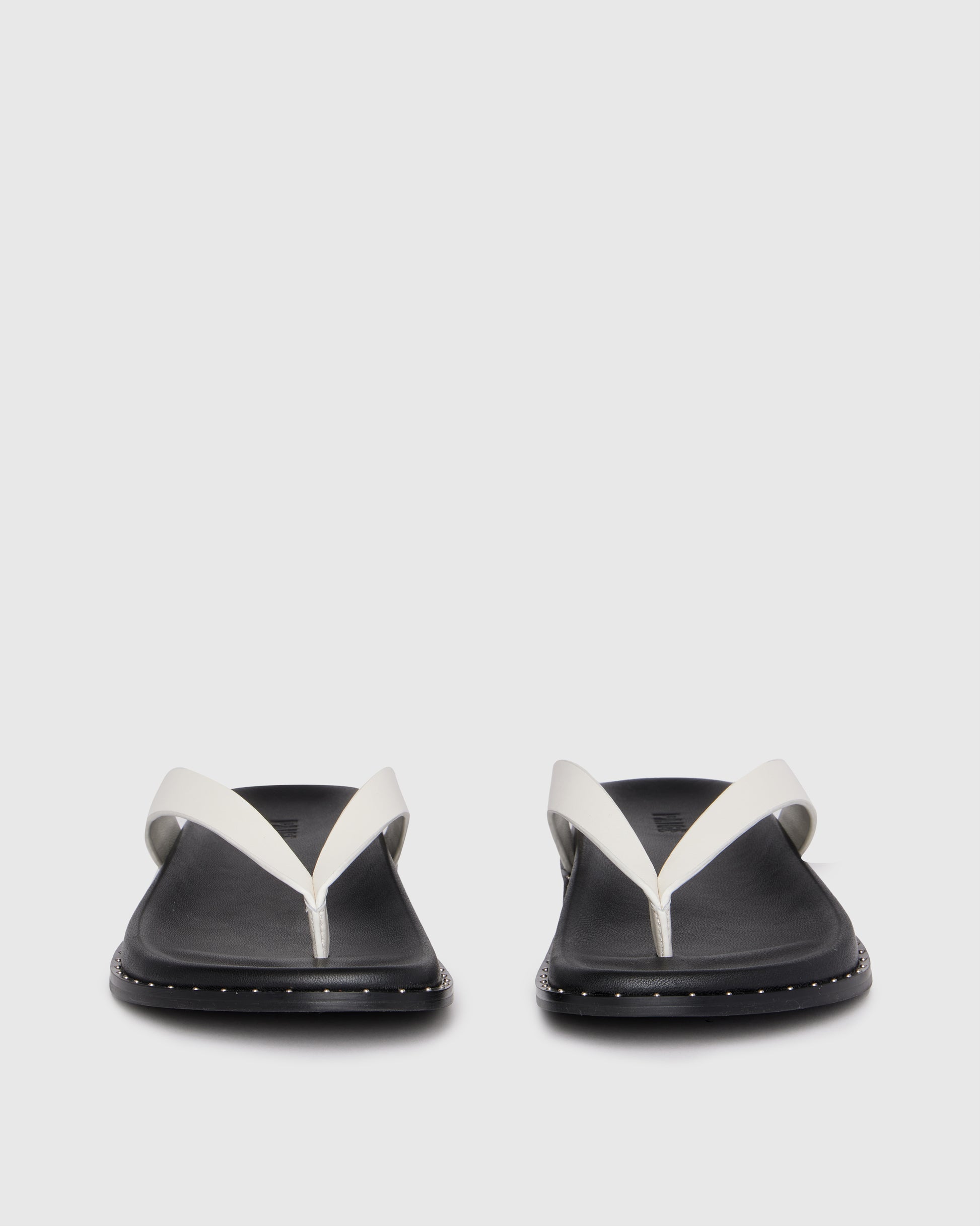 Pair of black sandals with white straps on a light gray background