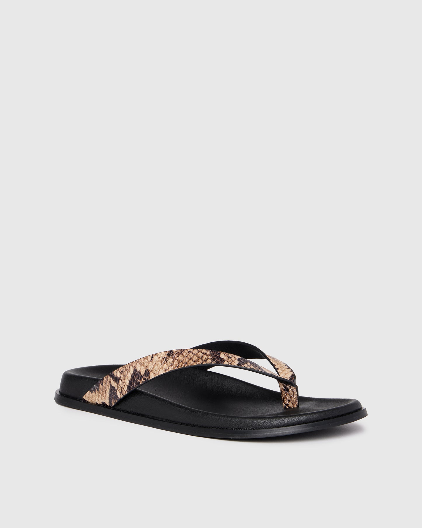 Black sandal with snake print strap on a light gray background