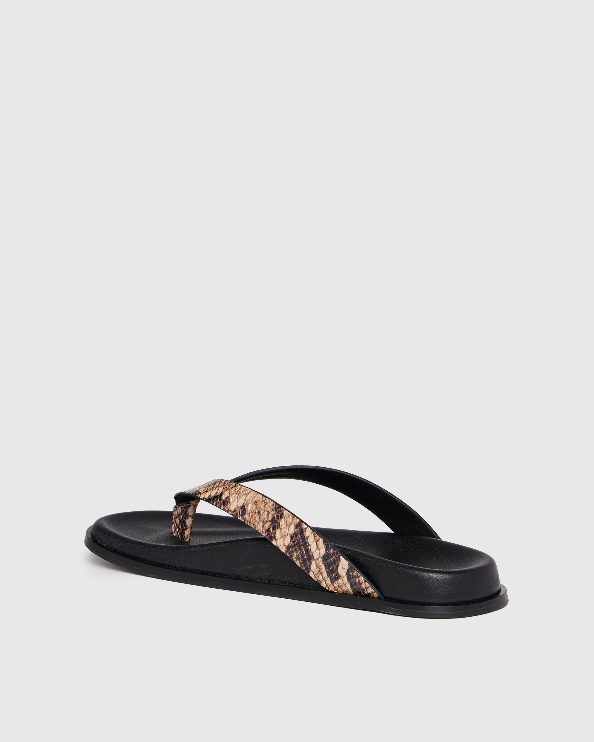 Black sandal with snake print strap on a light gray background