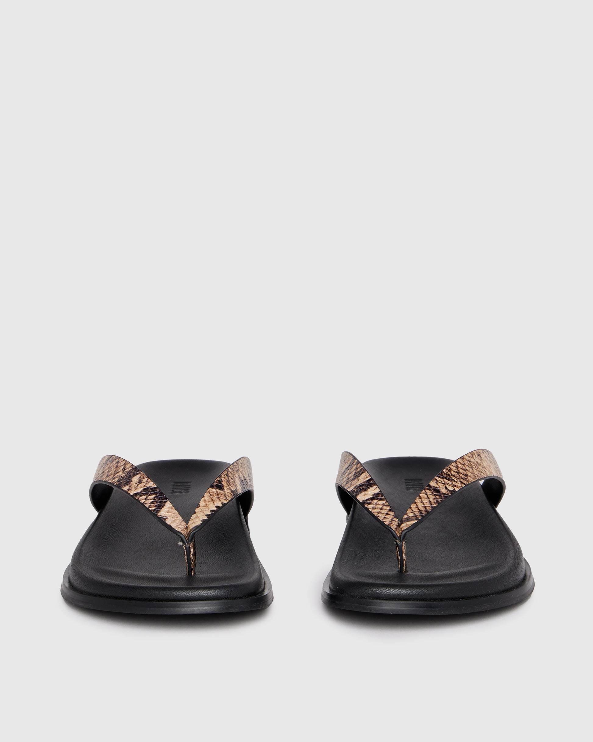 Black sandal with snake print strap on a light gray background