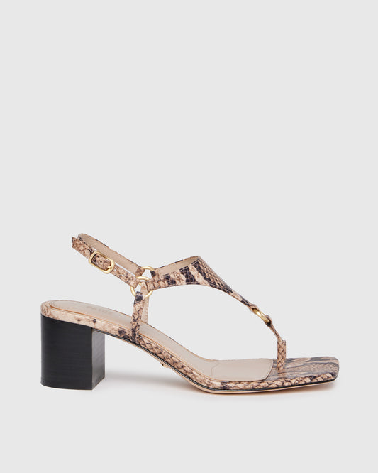 Snake print sandal with a black block heel on a light gray background