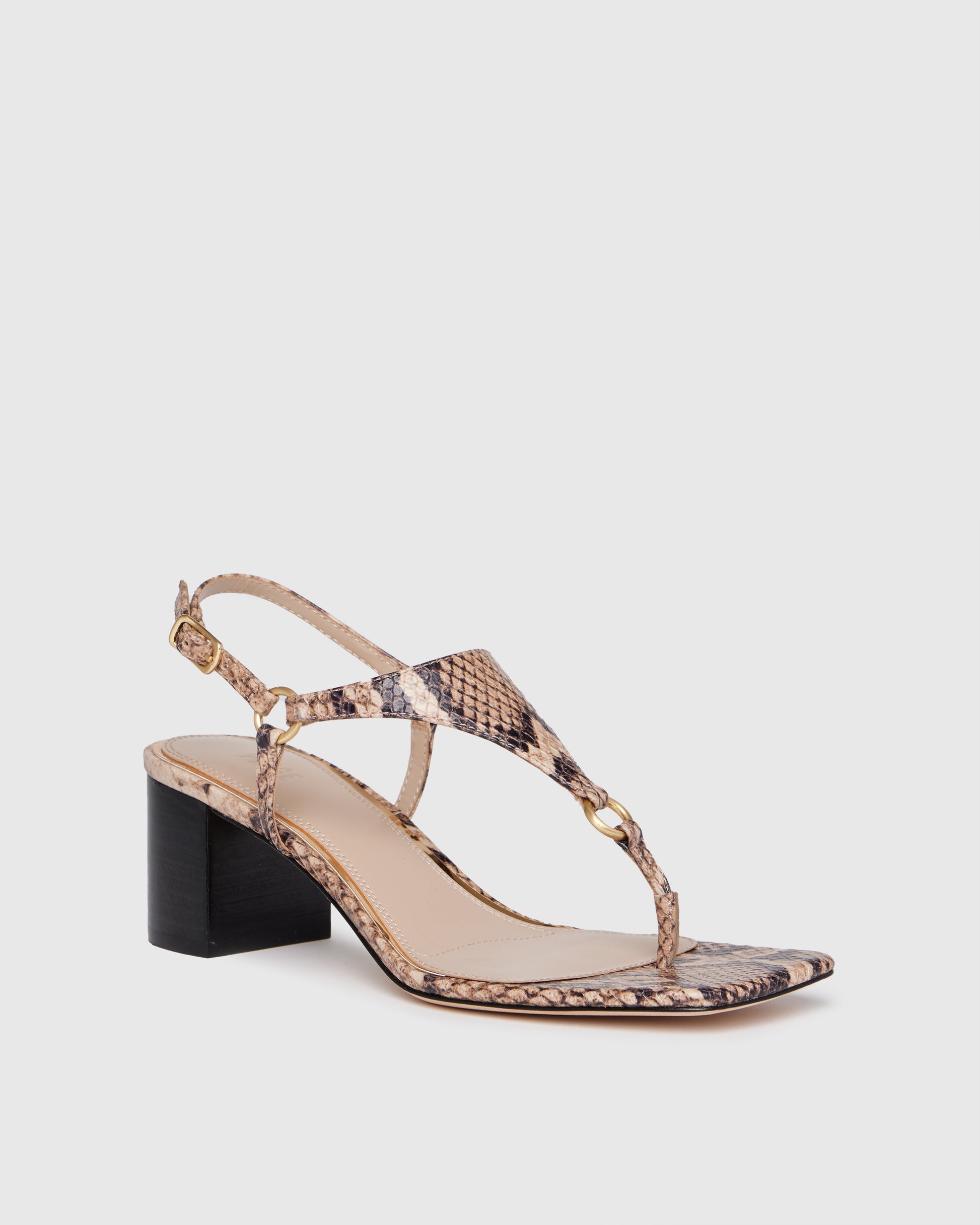 Snake print sandal with a black block heel on a light gray background