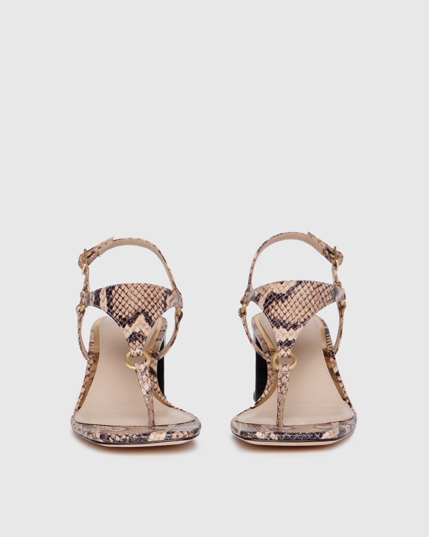 Snake print sandal with a black block heel on a light gray background