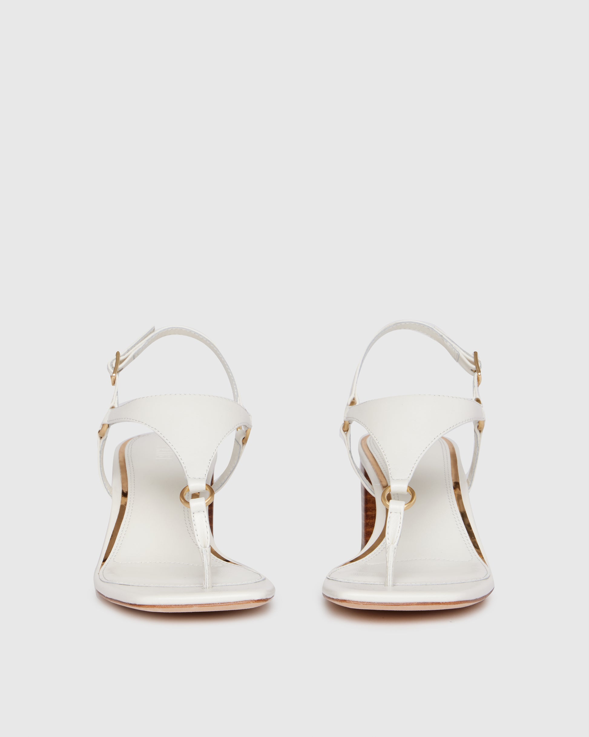 White sandal with wooden heel on a light gray background