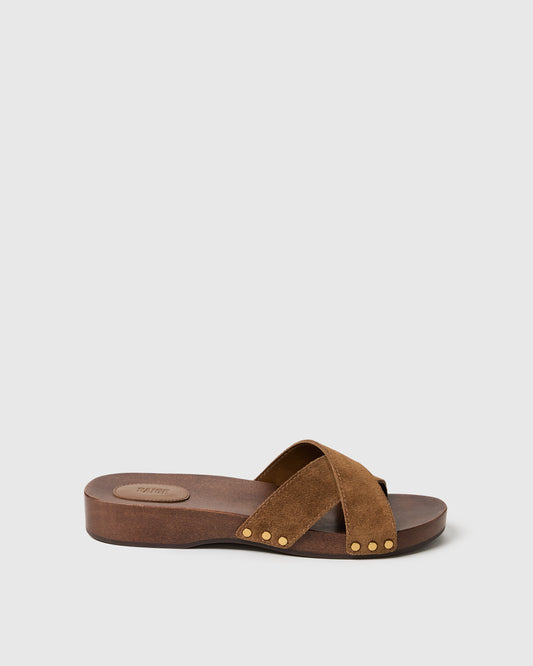Brown sandal with gold studs on a light gray background