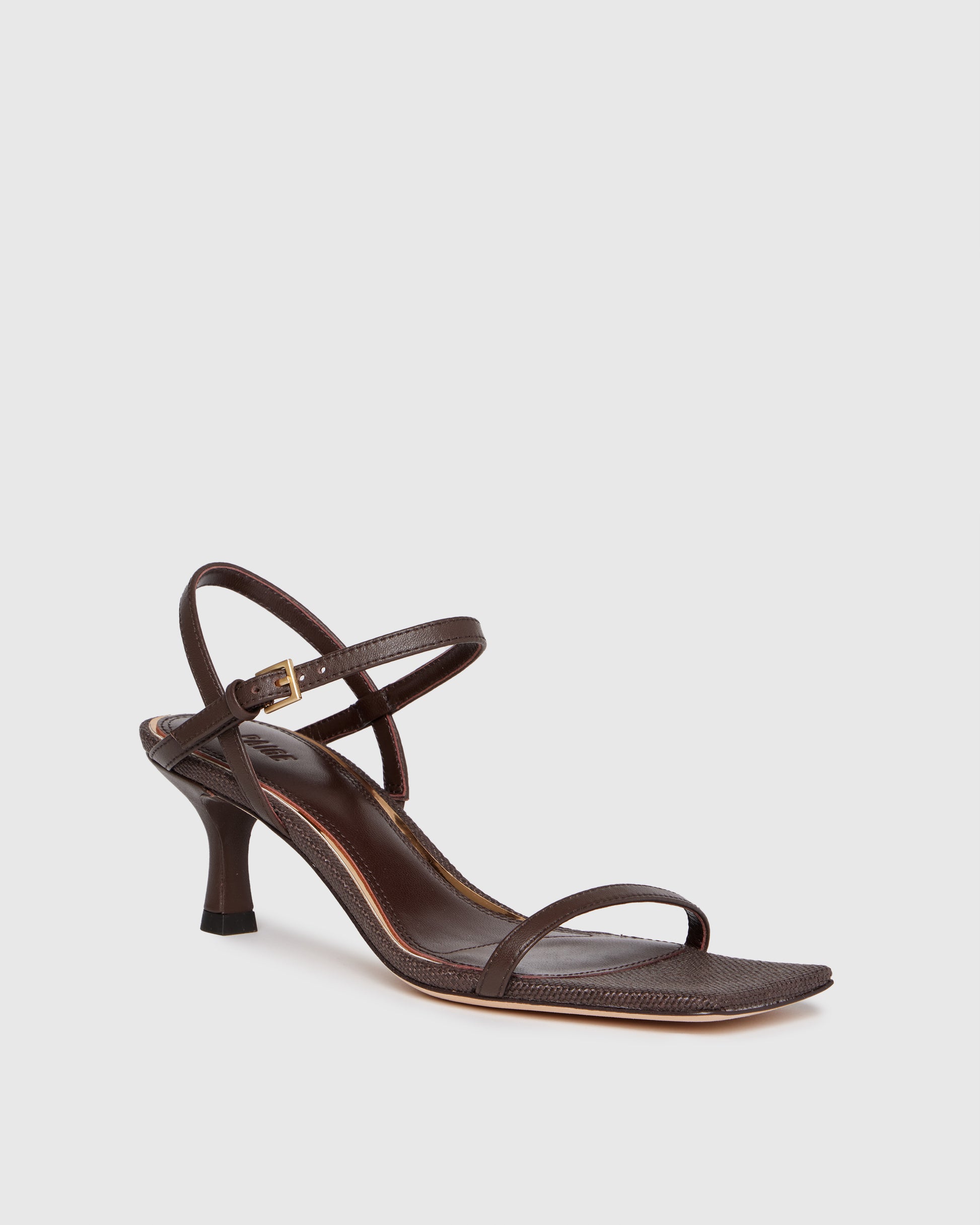 Brown high-heeled sandal with thin straps on a light gray background