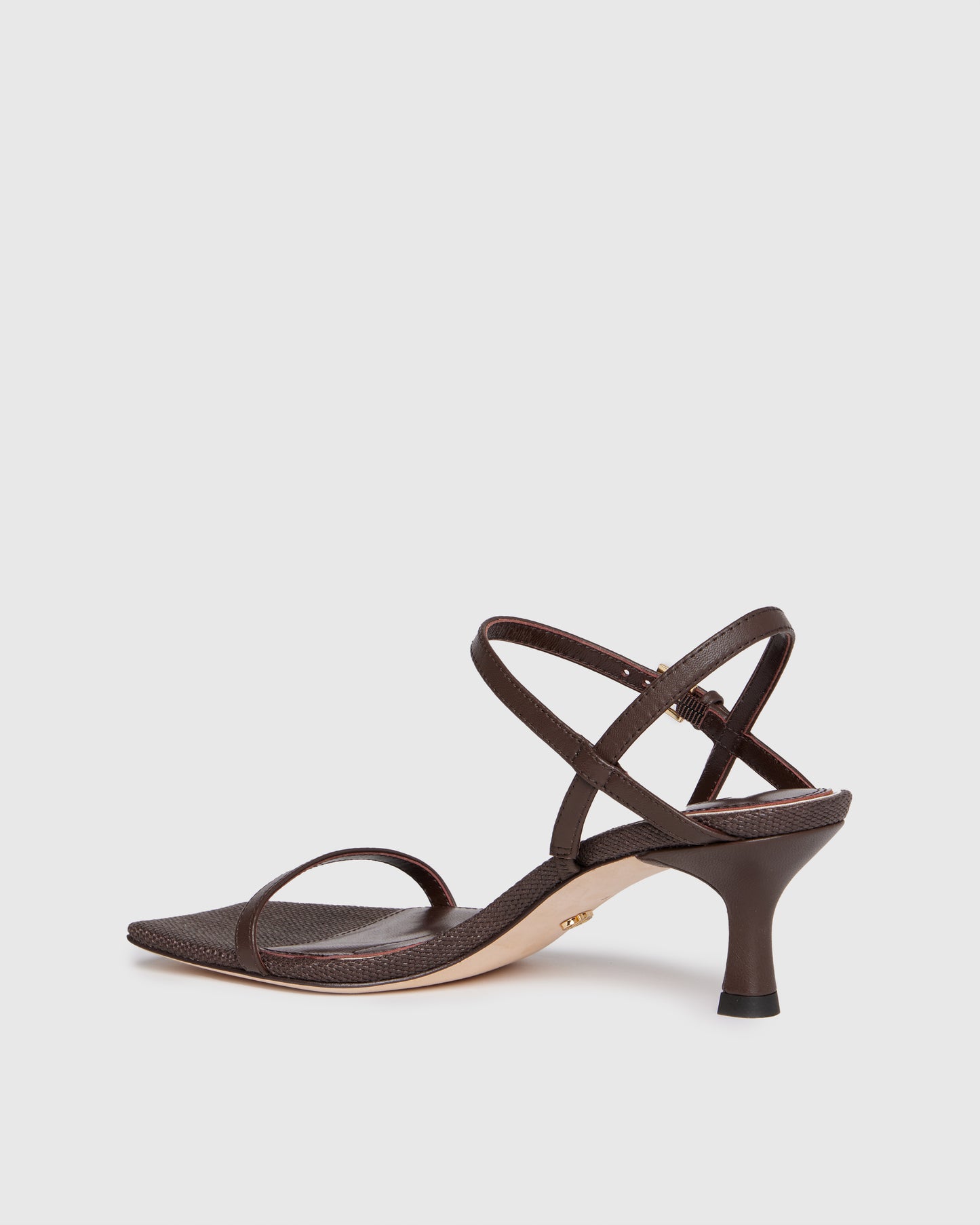 Brown high-heeled sandal with thin straps on a light gray background