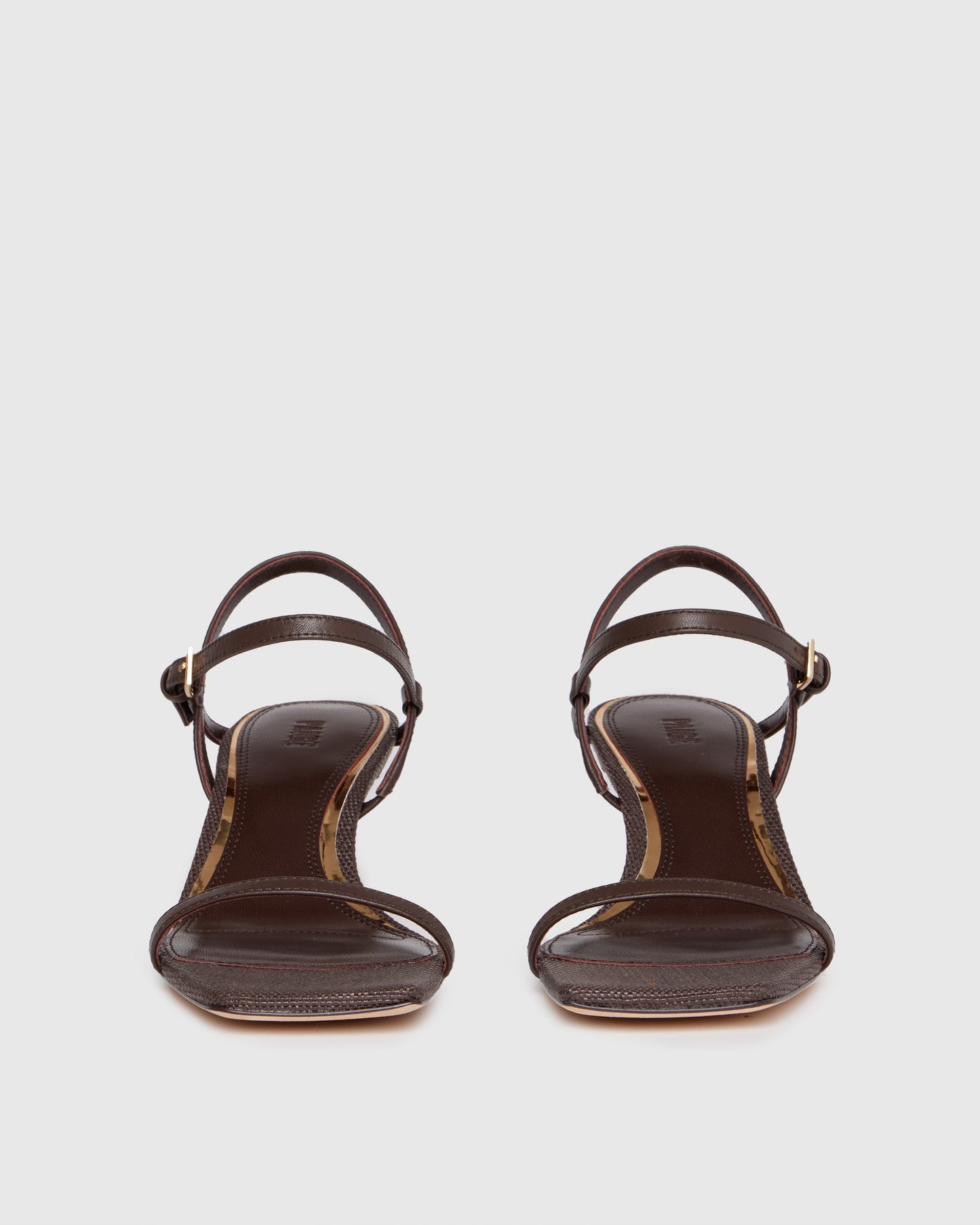 Brown high-heeled sandal with thin straps on a light gray background