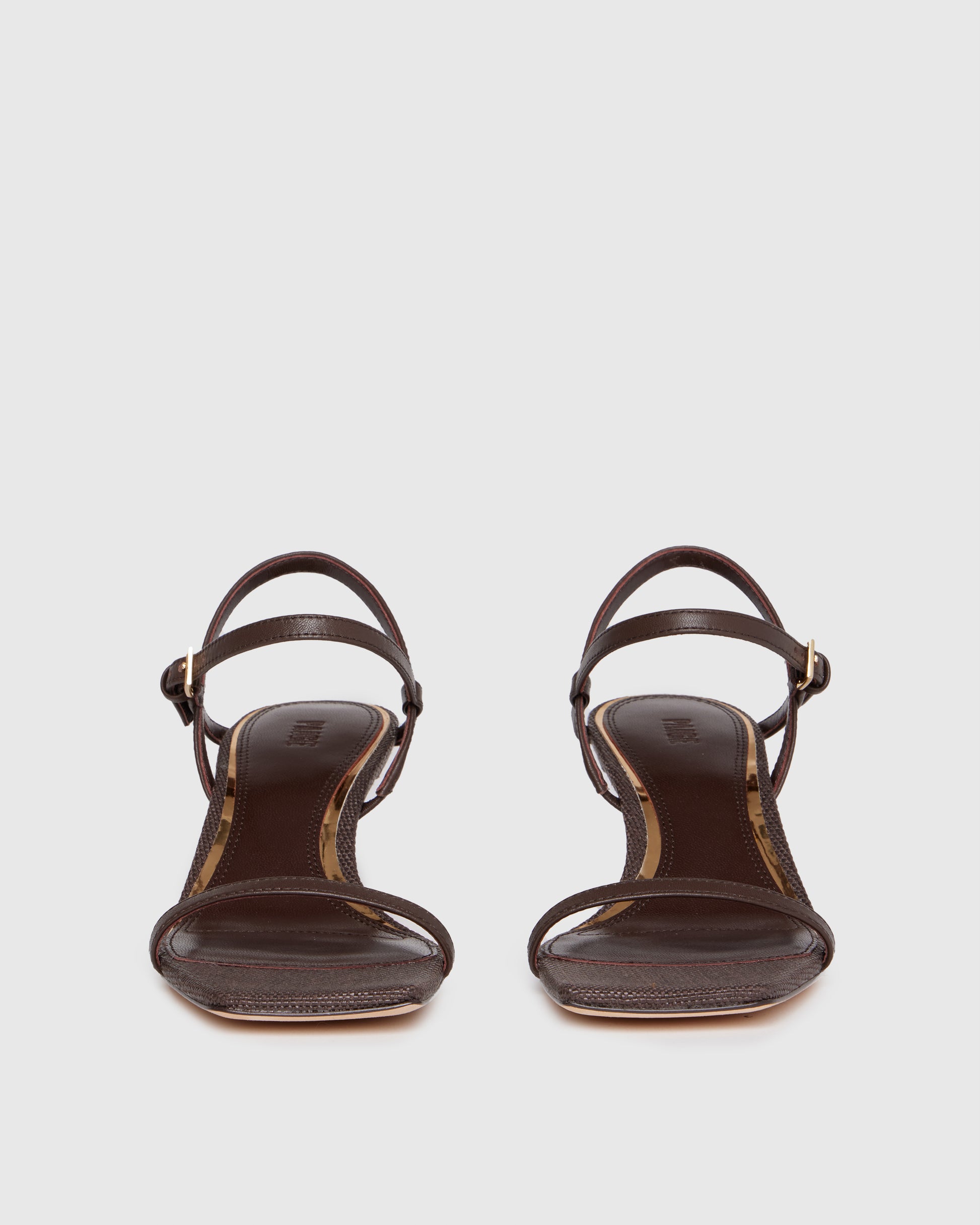 Brown high-heeled sandal with thin straps on a light gray background