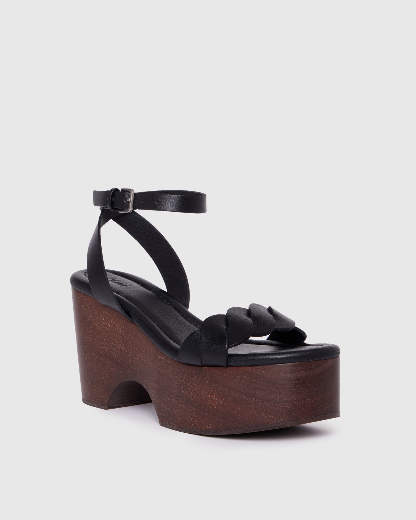 Black wedge sandal with wooden sole on a light gray background