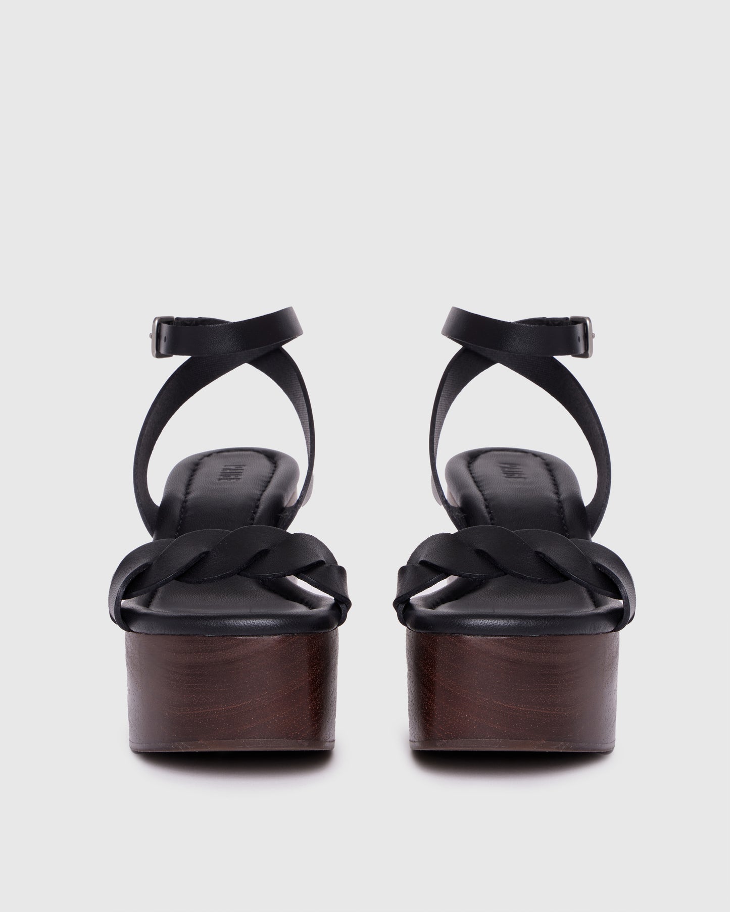 Black wedge sandal with wooden sole on a light gray background