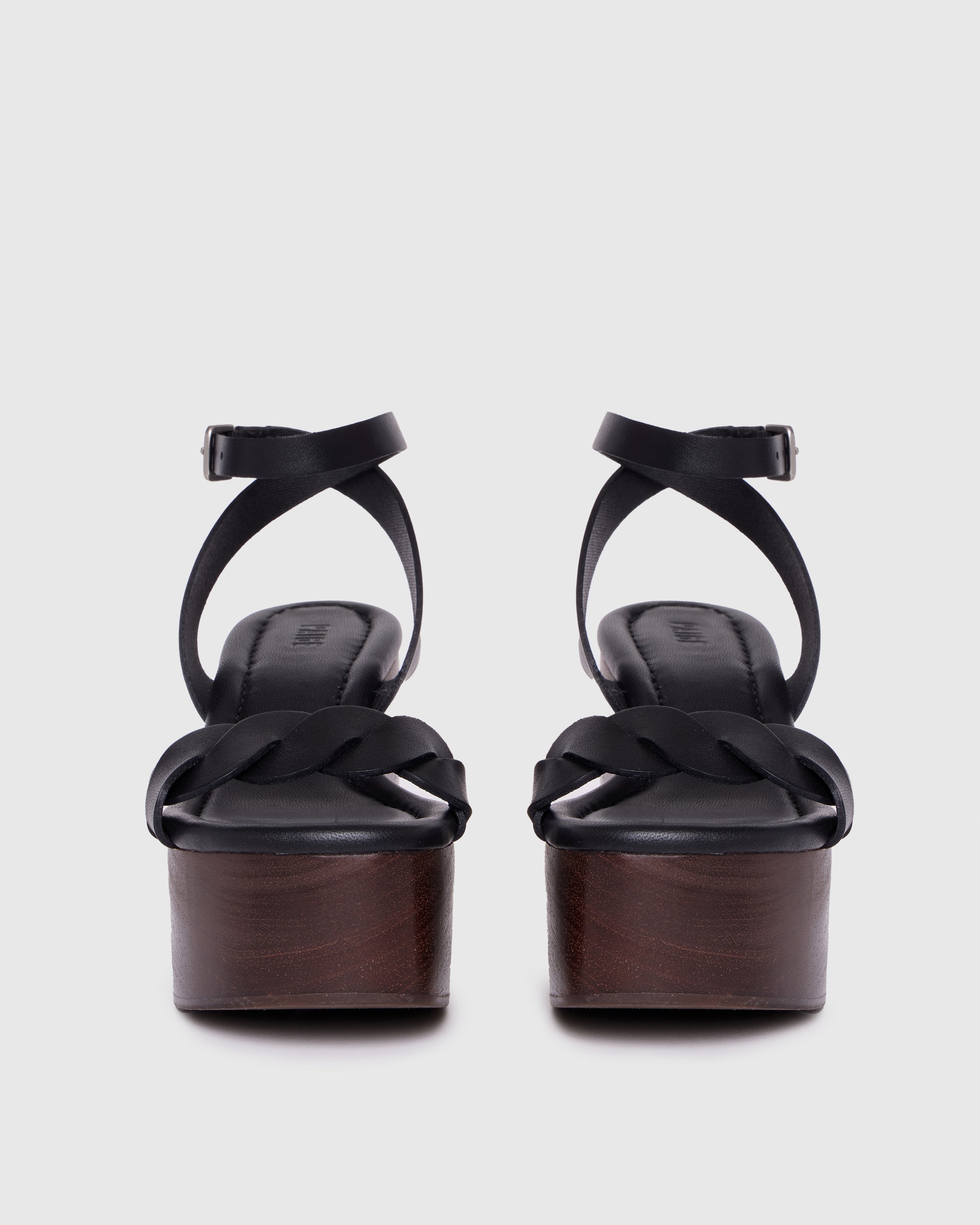 Black wedge sandal with wooden sole on a light gray background