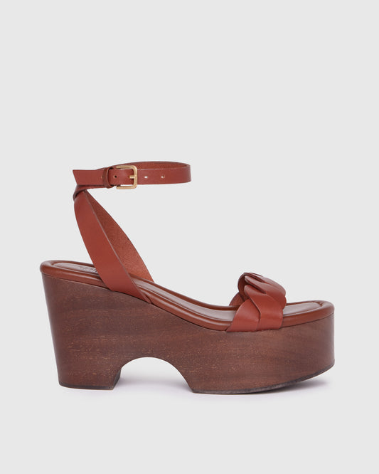 Brown platform sandal with wooden sole on a light gray background
