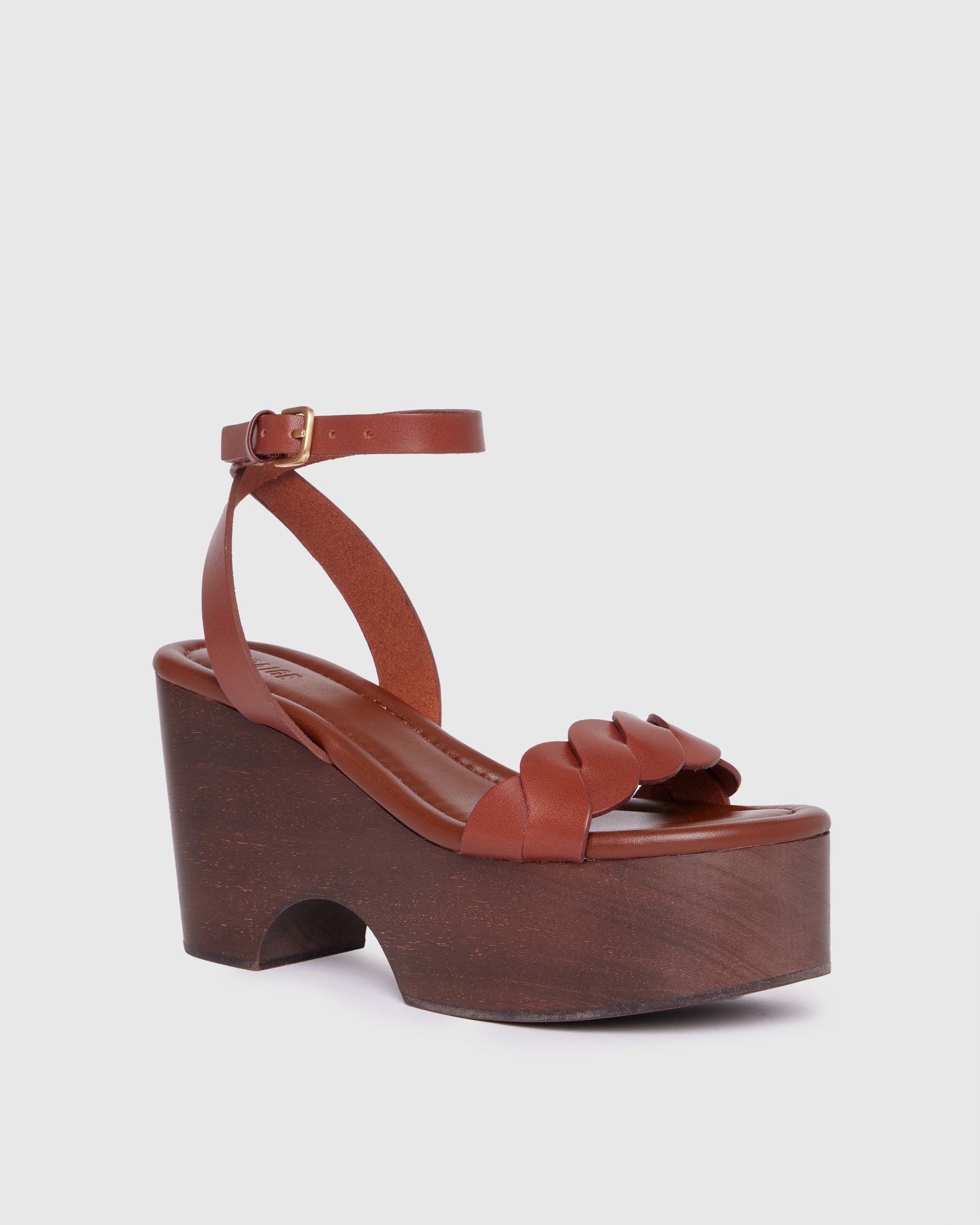 Brown platform sandal with wooden sole on a light gray background