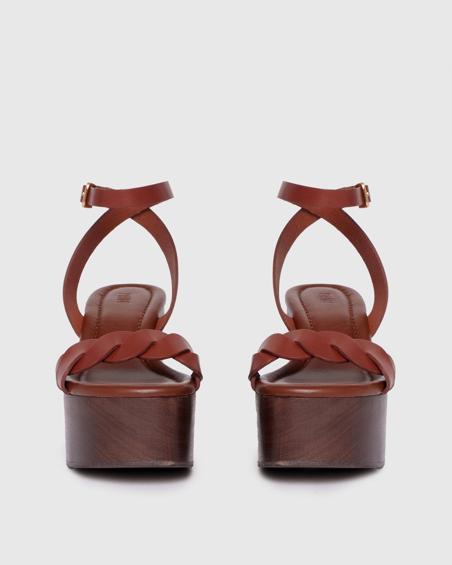 Brown platform sandal with wooden sole on a light gray background