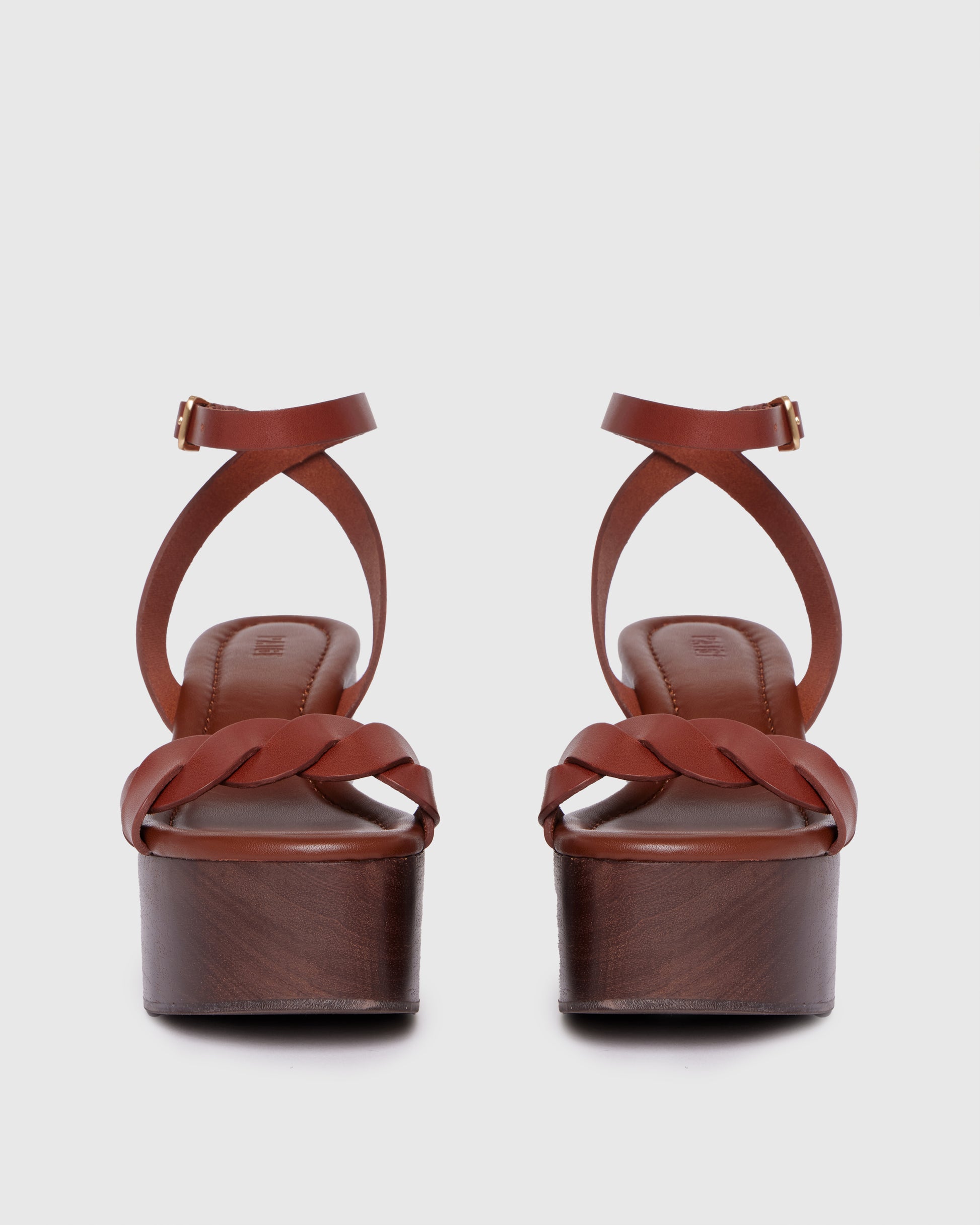 Brown platform sandal with wooden sole on a light gray background