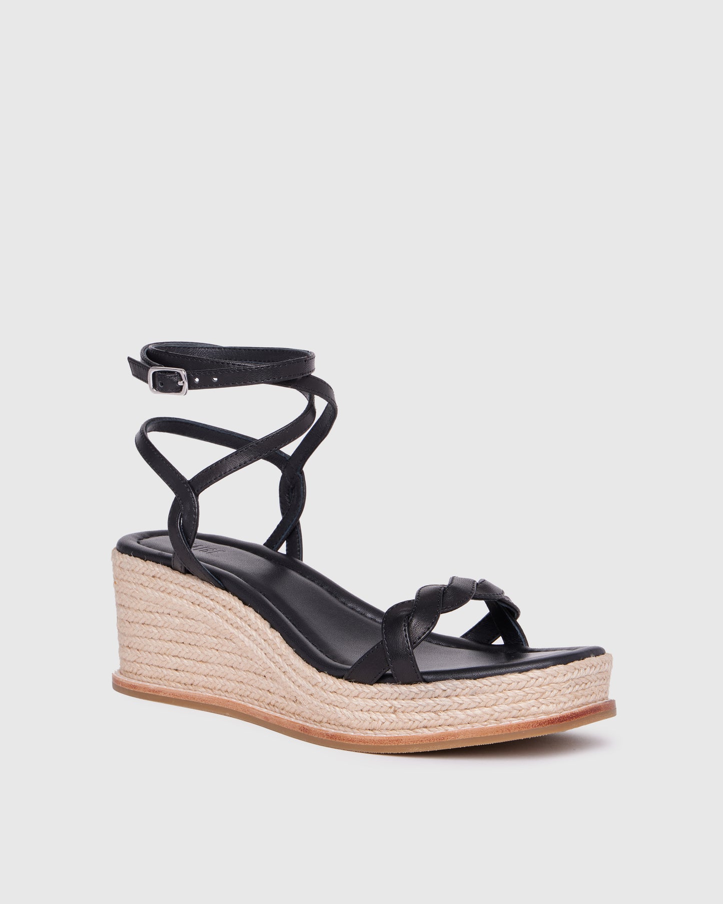 Black wedge sandal with espadrille sole on a light gray background