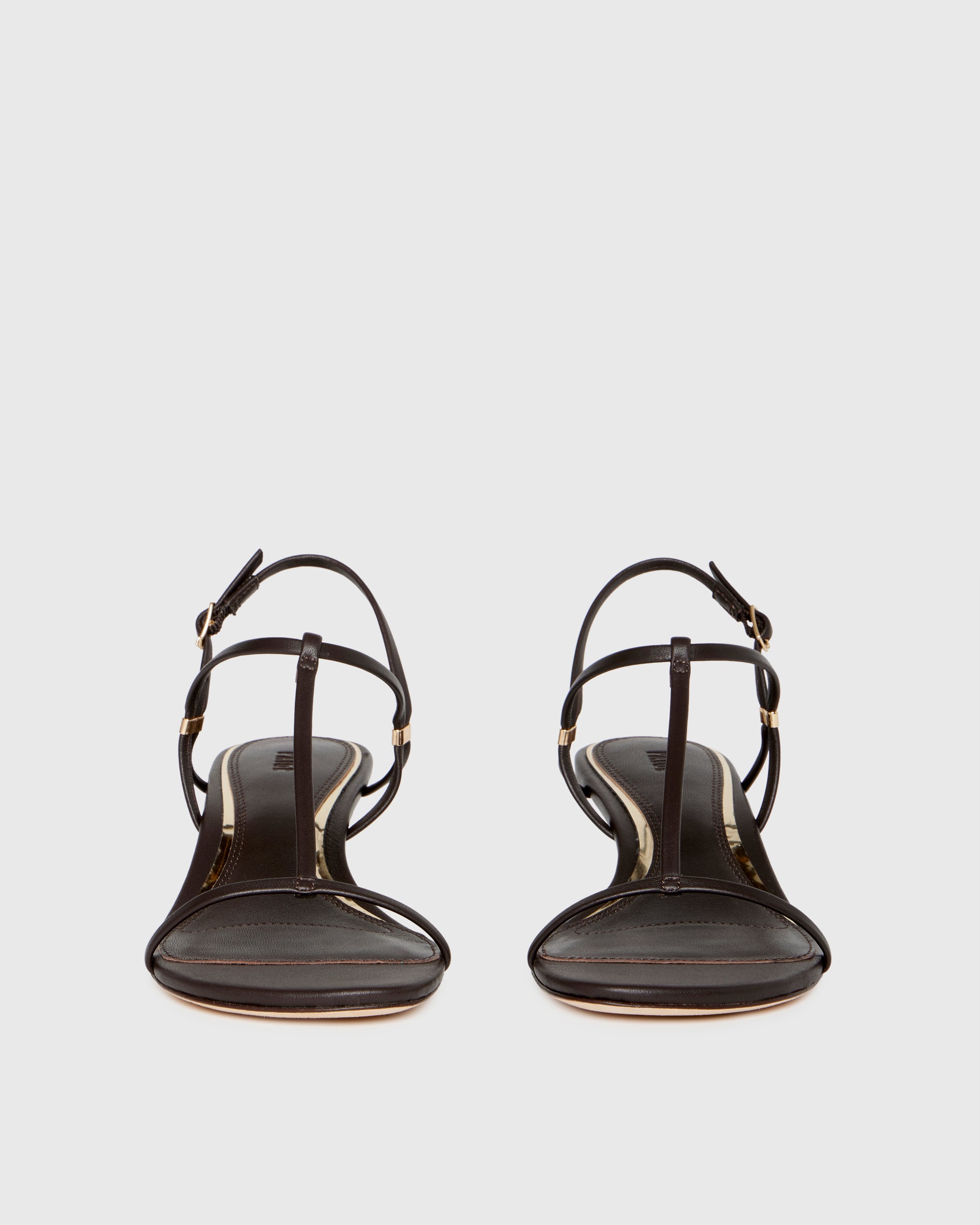 Chocolate wedge sandal with thin straps on a light gray background