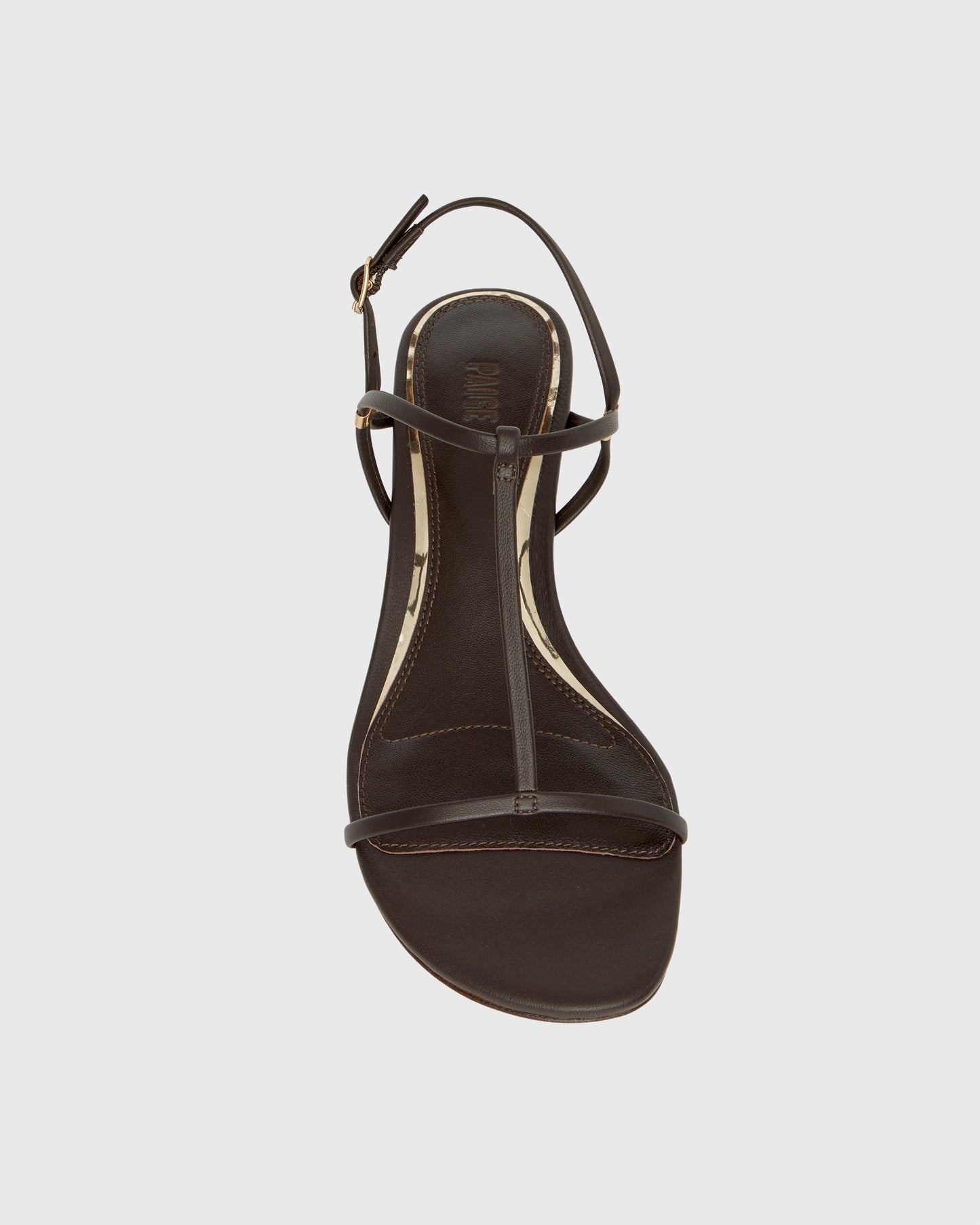 Chocolate wedge sandal with thin straps on a light gray background