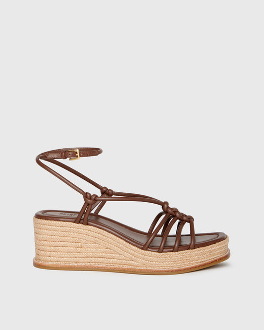 Brown wedge sandal with espadrille sole on a light gray background