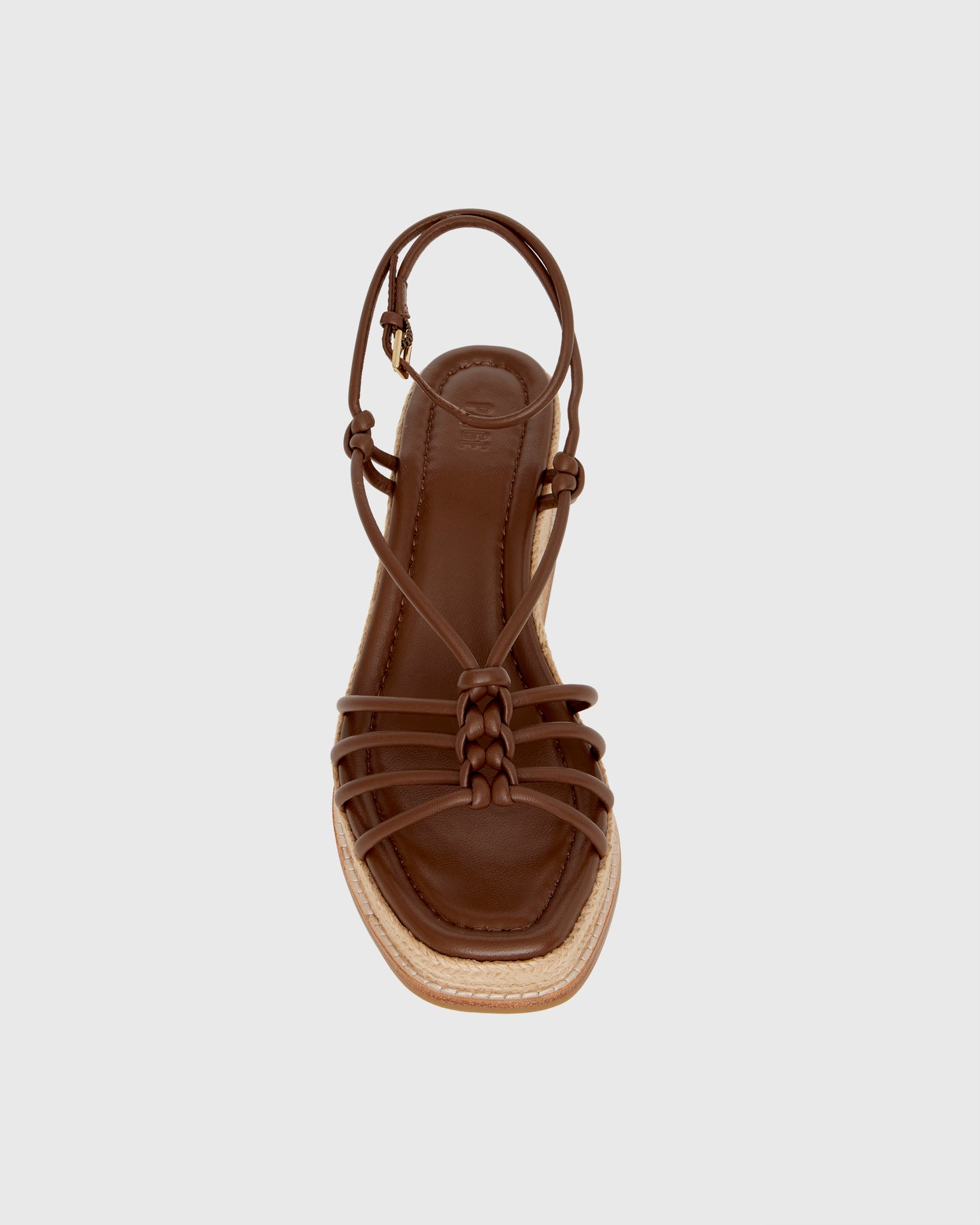 Brown wedge sandal with espadrille sole on a light gray background
