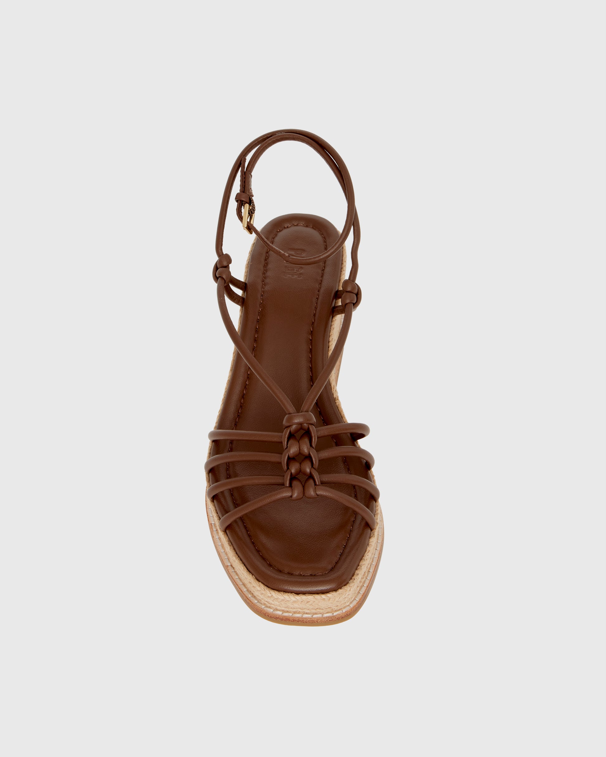 Brown wedge sandal with espadrille sole on a light gray background