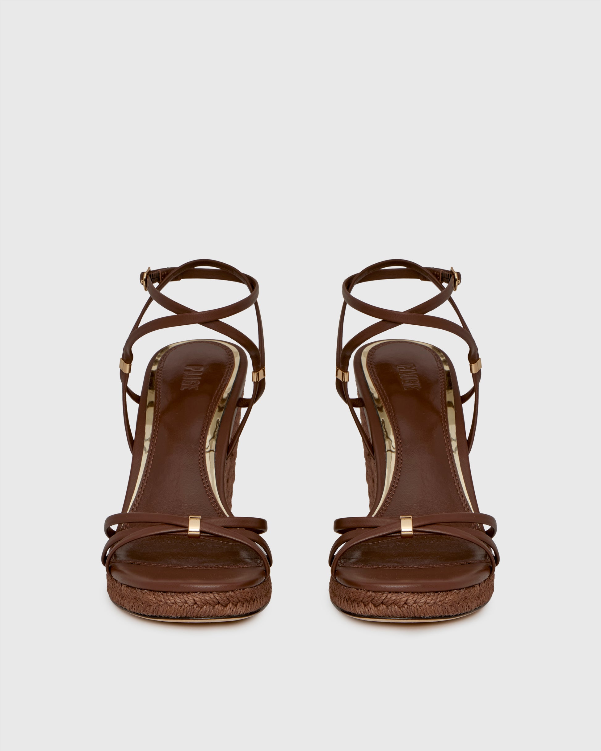 Brown wedge sandal with espadrille sole on a light gray background