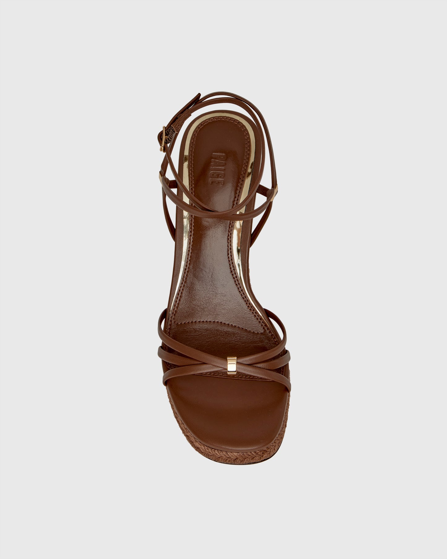Brown wedge sandal with espadrille sole on a light gray background