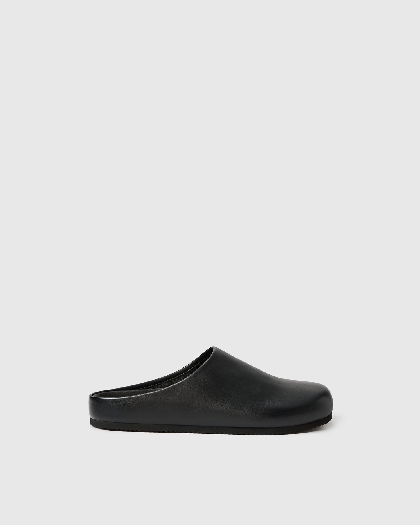 Black slip-on clog-style shoe with a smooth upper set against a white background.