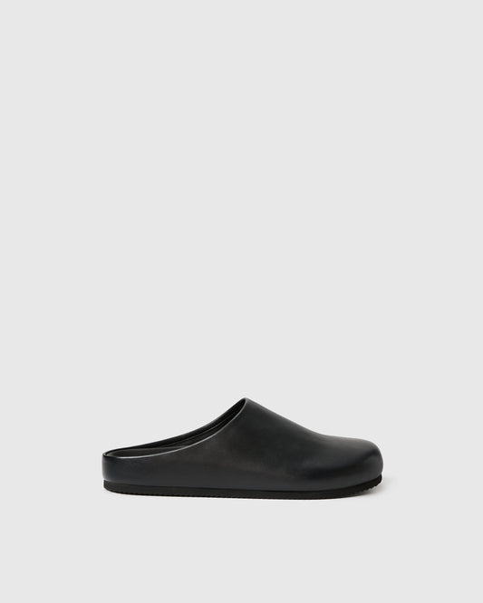 Black slip-on clog-style shoe with a smooth upper set against a white background.