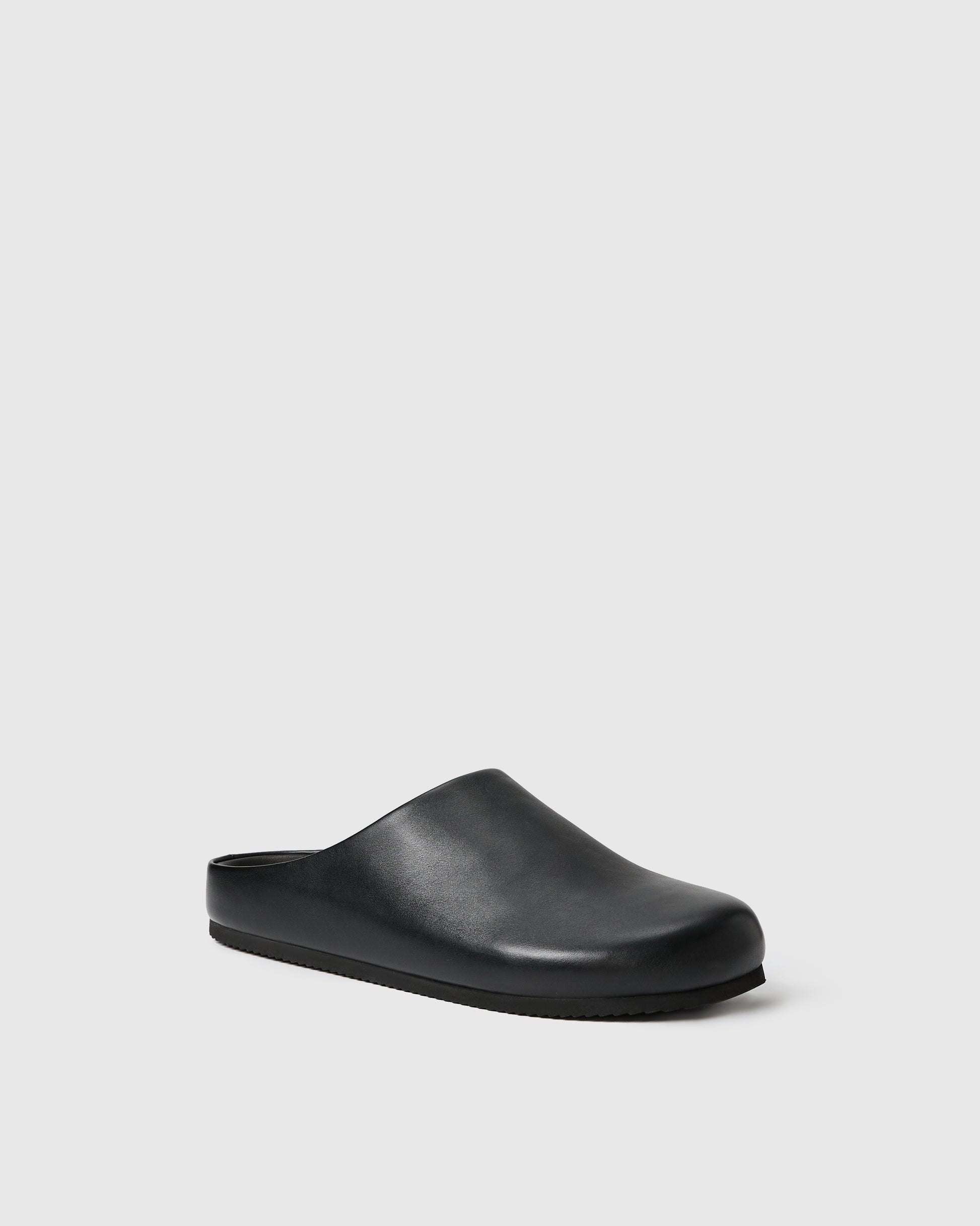 Black slip-on clog-style shoe with a smooth upper set against a white background.
