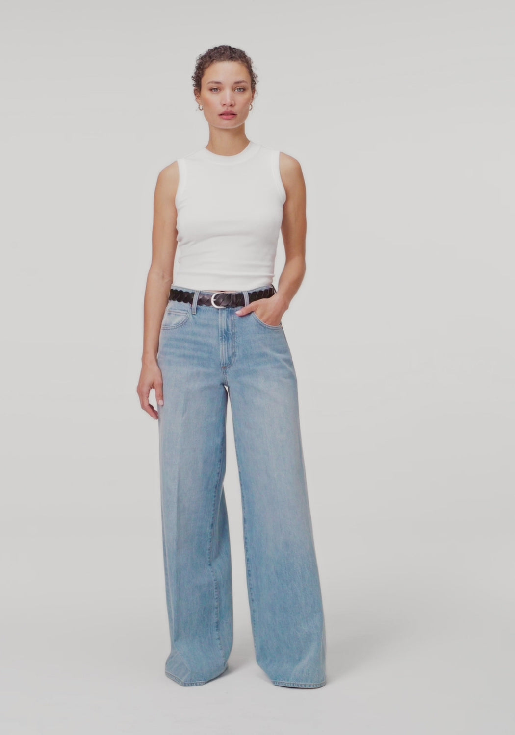 women wearing white top paired with blue jeans against white background